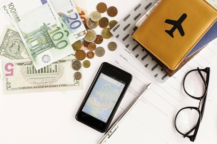 UK Temporary work – Creative & Supporting Visa 21 Travel documents, passport wallet, currency, and phone map used for UK visa preparation