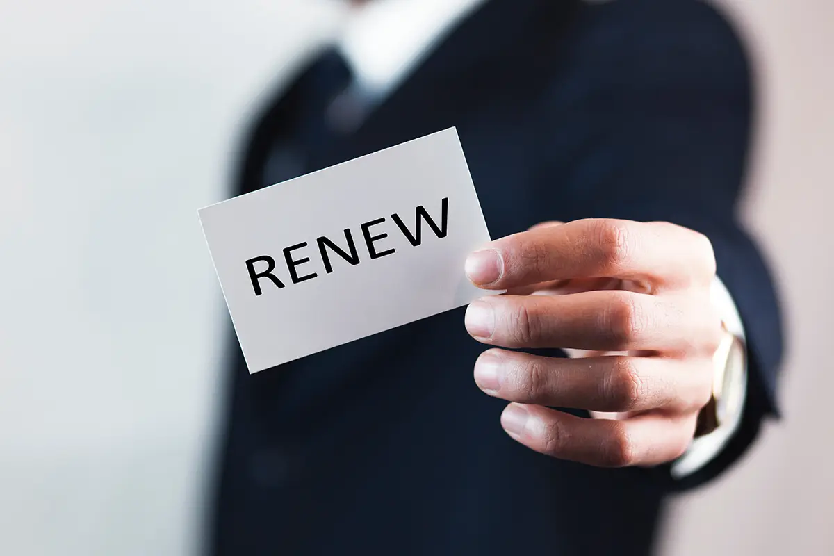 Business professional holding a card that says renew, symbolising UK sponsorship licence renewal