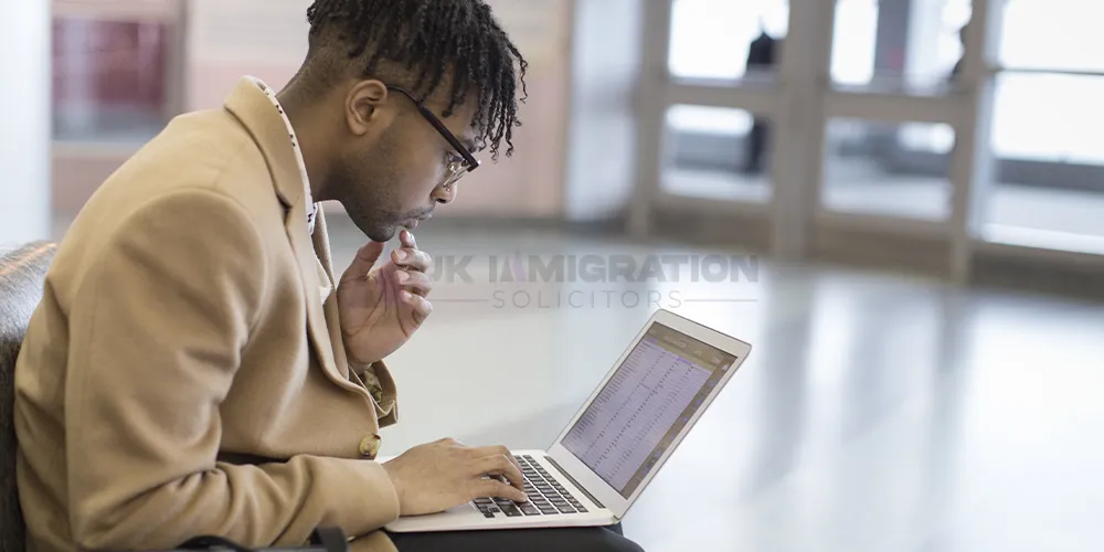International graduate reviewing documents for a UK Graduate Visa application on a laptop