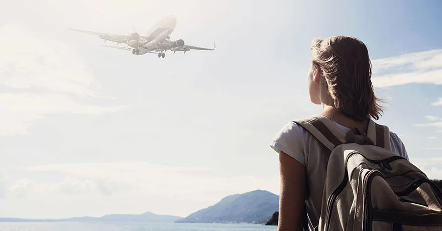 Student traveller watching an airplane take off, symbolising the Short-Term Student Visa UK